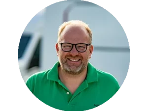 Maik Tillmann, lächelnd mit Brille, vor einem Wohnmobil