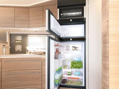 Dethleffs Alpa Küche mit offenem Kühlschrank und Einbauschränken