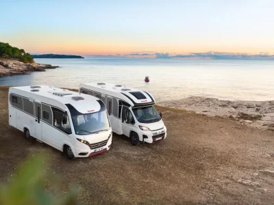 Dethleffs Trend zwei Teilintegrierte am Strand bei Sonnenuntergang