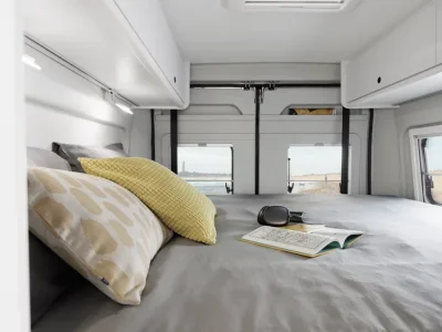 Etrusco Campervan Schlafbereich mit zwei Kissen und offenem Buch