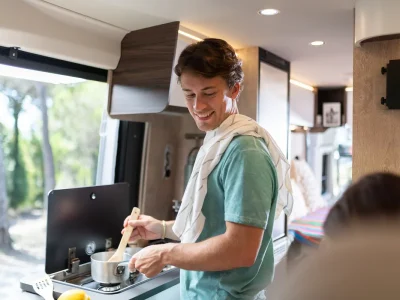 Laika Ecovip Küche mit Kochfeld und Mann beim Kochen