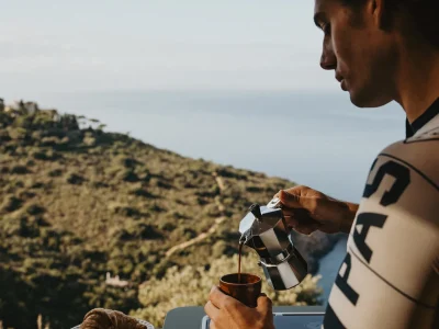 Laika Kosmo Campervan mit Mann, der Kaffee in Tasse gießt, Blick aufs Meer